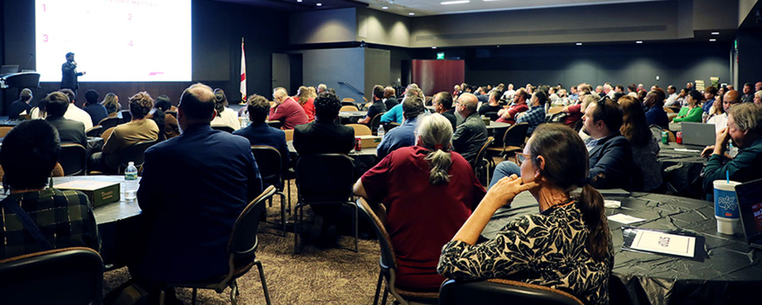 Conference room filled with FSU employees watching a presentation