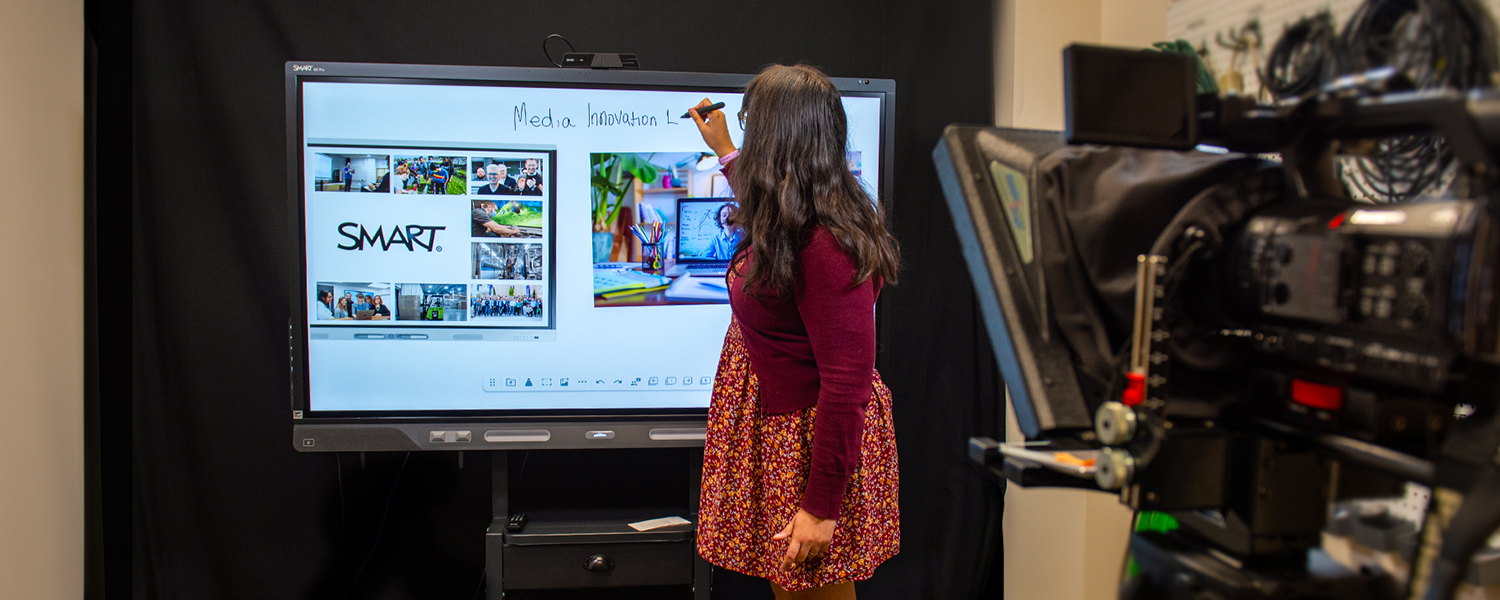 Instructor writing on a SMART board