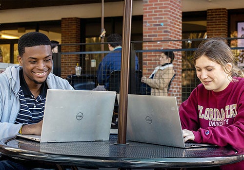 Image of a two students working on their laptops