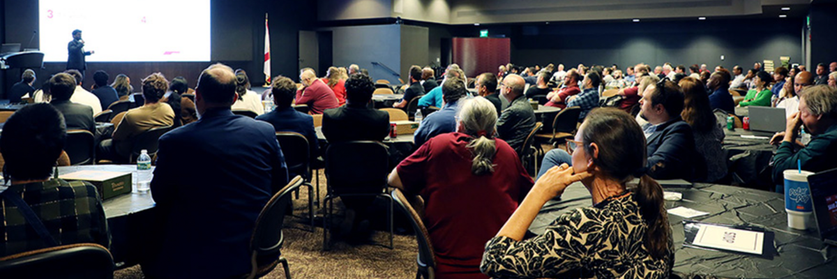Conference room filled with FSU employees watching a presentation