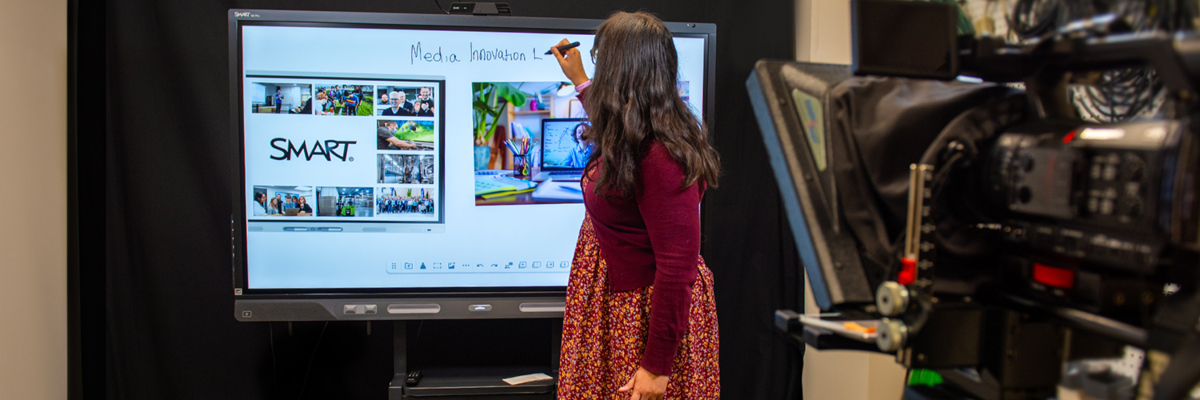Instructor writing on a SMART board