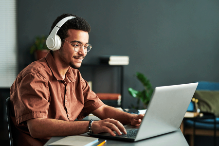 Man working on laptop with headphones on